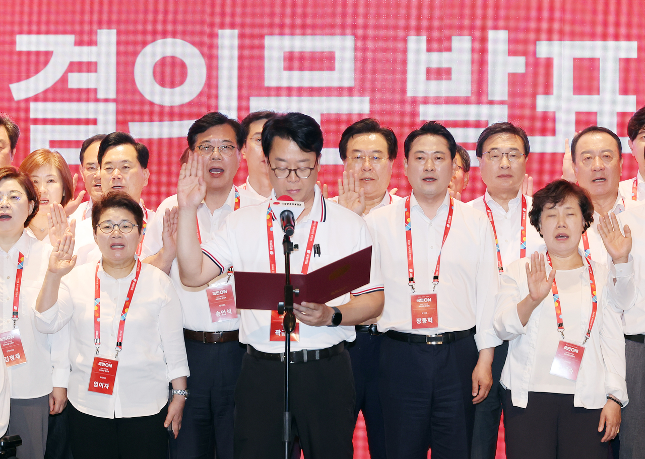 Lawmakers, including People Power Party leader Rep. Jang Dong-hyeok  (front, second from right) and floor leader Rep. Song Eon-seog (second row, second from right), read out a resolution during the party’s workshop at the Aviation Training Center of Incheon Airport on Friday. (Yonhap)