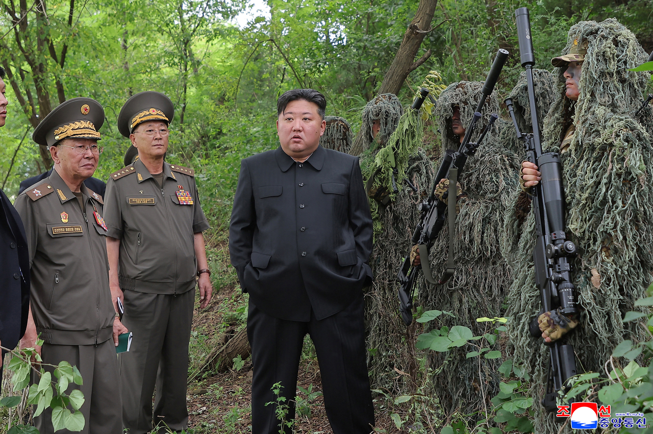 North Korean leader Kim Jong-un (center) speaks to officials during his visit to a special operations training base, affiliated with the North Korean military's General Staff, at an unspecified location on Aug. 27 to inspect how the sniper and special forces are trained, in this photo released by the Korean Central News Agency the following day. (Yonhap)