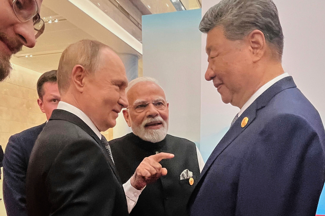 Russian President Vladimir Putin (left,) Indian Prime Minister Narendra Modi (center) and Chinese President Xi Jinping talk ahead of the Shanghai Cooperation Organization summit on Monday.  AP-Yonhap