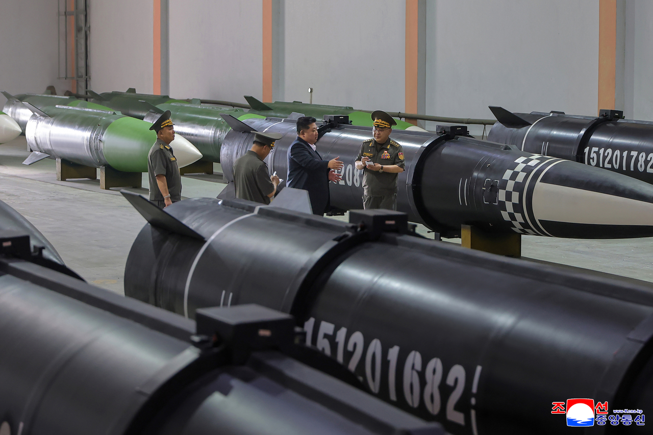 North Korean leader Kim Jong-un (second from right) inspects a new munitions factory at an unspecified location on Sunday to review the country's capability to produce missiles ahead of his upcoming visit to Beijing to attend a Chinese military parade, in this photo released by the North's official Korean Central News Agency on Monday. (Yonhap)