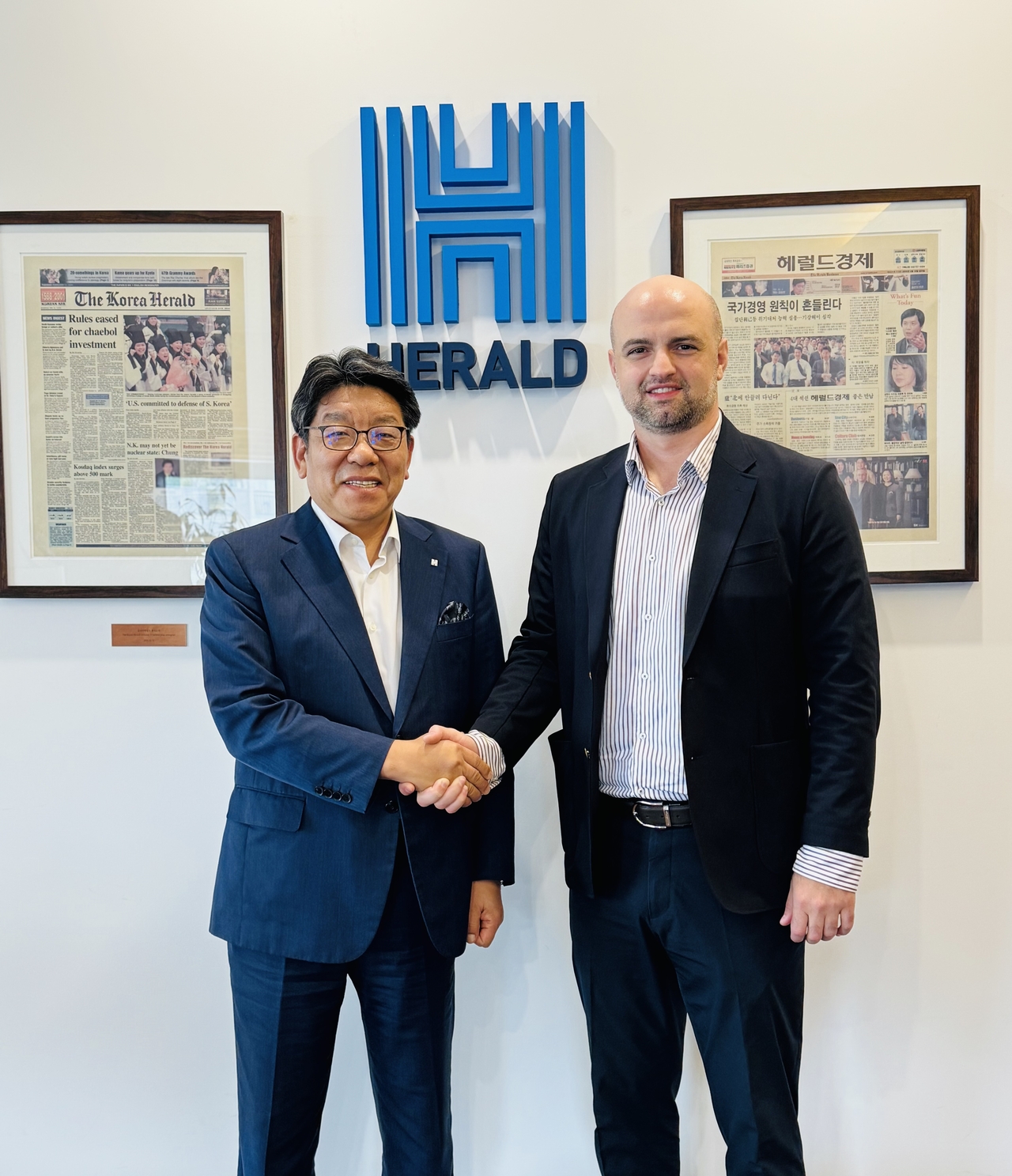 Herald Media Group CEO Choi Jin-young (left) and Georgian Ambassador to Korea Tarash Papaskua pose for a  photo at the Herald Square Herald Corp. headquarters in central Seoul, Friday. (Sanjay Kumar/The Korea Herald)
