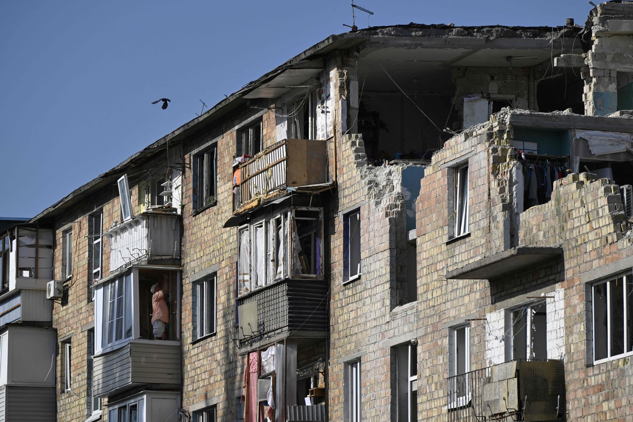 A local resident collects belongings in a residential building heavily damaged by a Russian attack, Sunday. (AFP-Yonhap)
