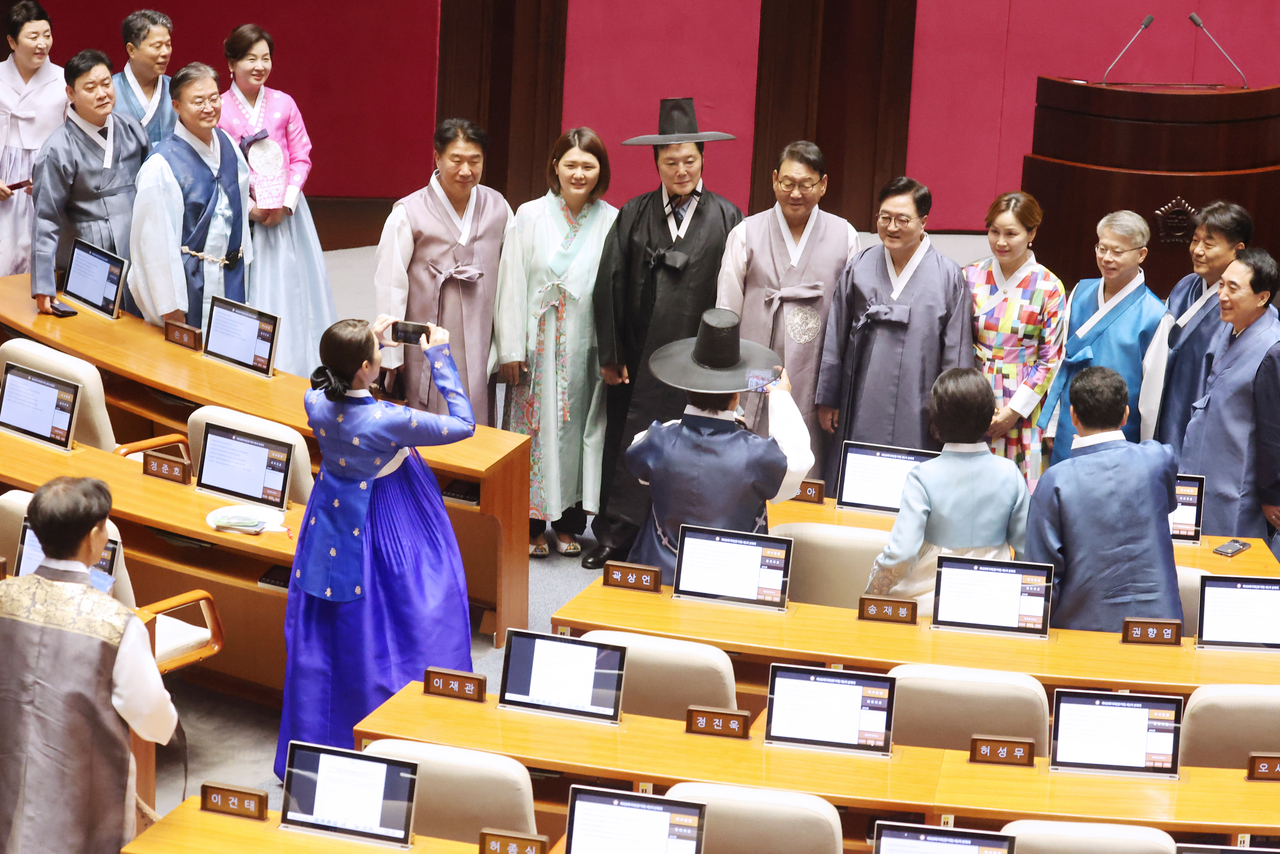 Lawmakers from the ruling Democratic Party of Korea, dressed in traditional hanbok, pose for photos at the National Assembly in Seoul on Monday. (Yonhap)