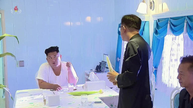 A scene from 2022 documentary film "The Father of the People" shows North Korean leader Kim Jong-un (left) inside an onboard office in his armored train. (Korean Central Television via Yonhap)