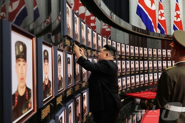 North Korean leader Kim Jong-un places national hero medals beside portraits of soldiers killed while serving in the Russia-Ukraine war, during a commendation ceremony held on Aug. 22. (Rodong Sinmun via News1)
