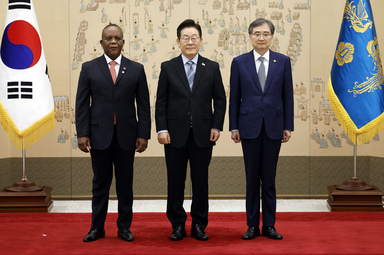New Angolan Ambassador to South Korea Sianga Kivuila Samuel Abilio (left) poses for a photo with President Lee Jae Myung (center) and Foreign Minister Cho Hyun at a ceremony in the presidential office in Yongsan, Seoul, Tuesday. (Yonhap)