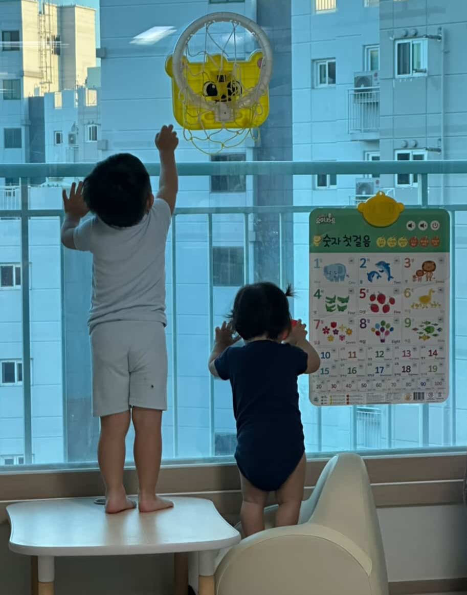 Yang’s son (left) and daughter look out the window of their apartment. (Yang)
