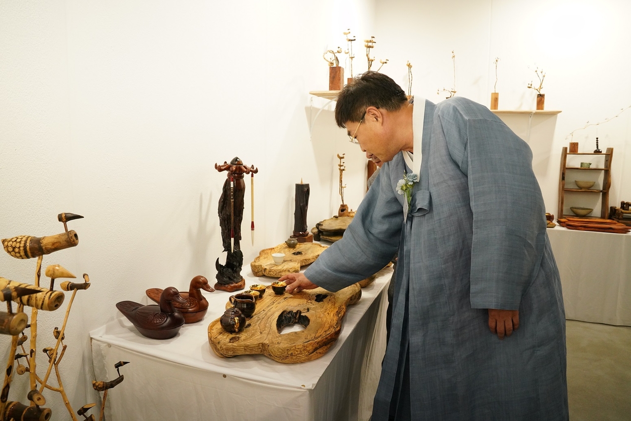 A visitor dressed in hanbok looks at an antique item displayed at Jongno-gu's 2023 antique fair. (Jongno-gu District Office)