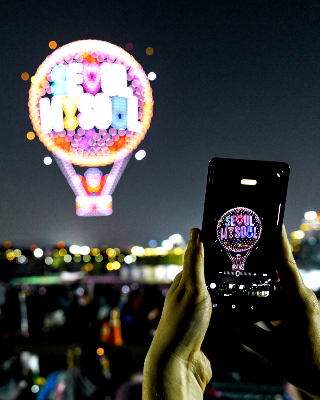A spectator photographs a nighttime drone show in May. (Seoul Metropolitan Government)