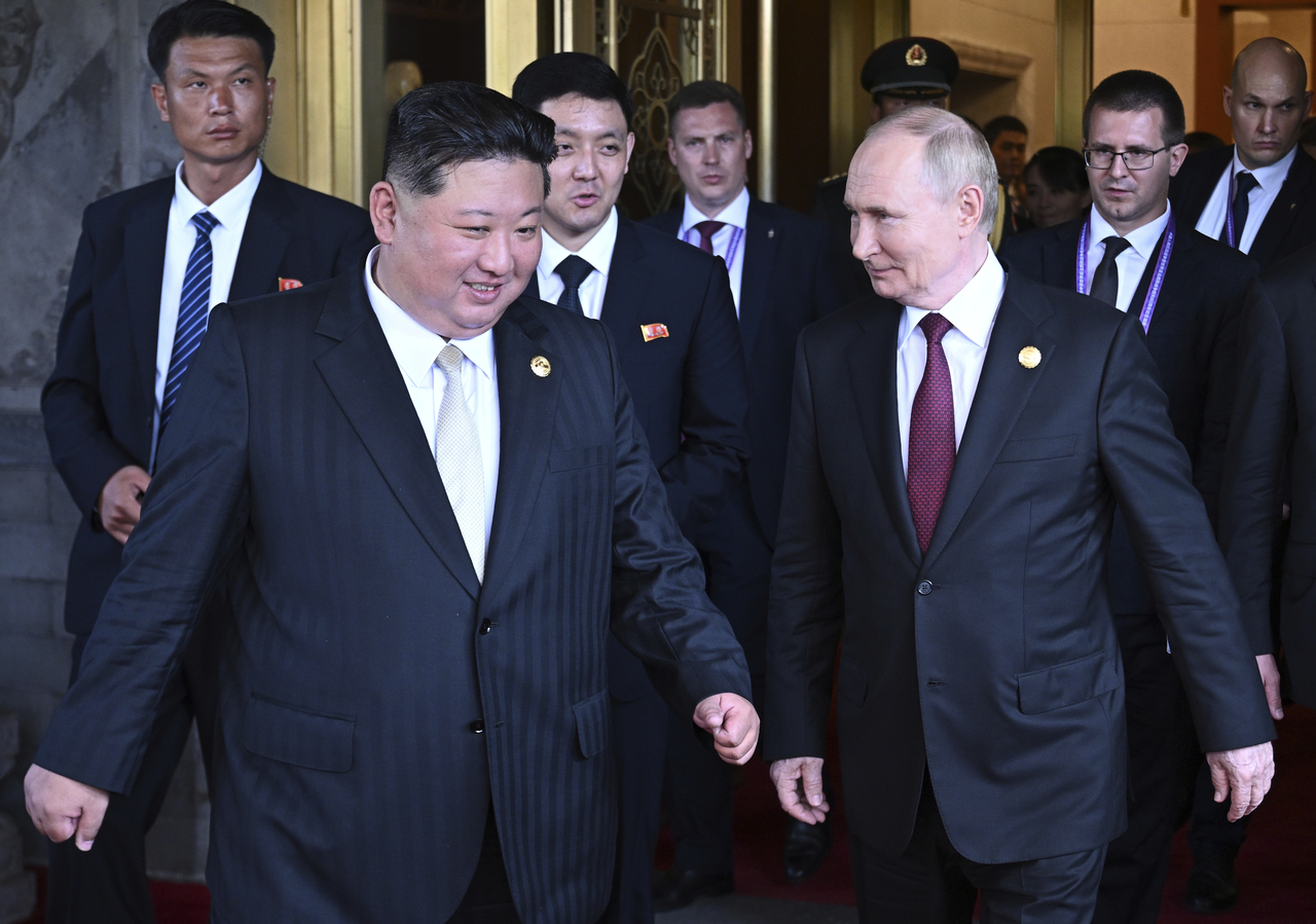 Russian President Vladimir Putin (right) and North Korean leader Kim Jong-un walk after their meeting at Diaoyutai State Guesthouse in Beijing, Wednesday. (Pool photo via AP-Yonhap)