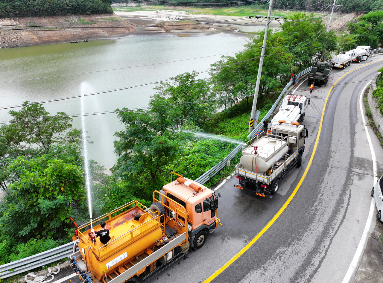 Water tanker trucks spray water into the Obong Reservoir in Gangneung, Gangwon Province, due to a prolonged drought. (Yonhap)