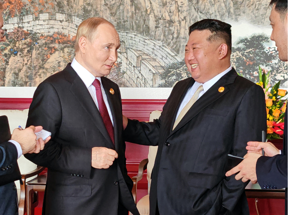 This photo shows North Korean leader Kim Jong-un (right) talks with Russian President Vladimir Putin during their summit in Beijing on Wednesday. (Yonhap)