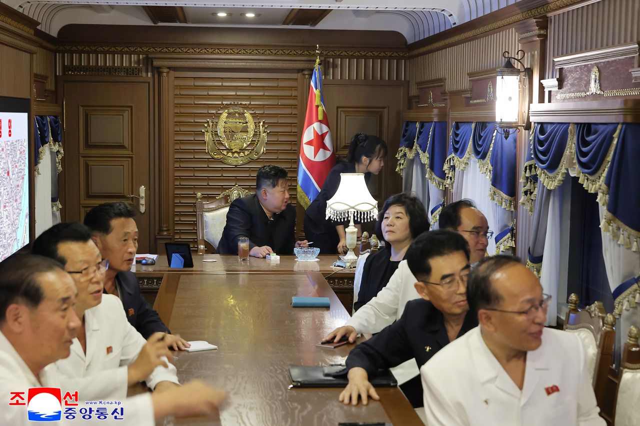 This photo, carried by North Korea's official Korean Central News Agency on Friday, shows the North's leader Kim Jong-un (center) and his daughter Ju-ae on his private train as he visited Beijing to attend China's military parade earlier this week. (Yonhap)