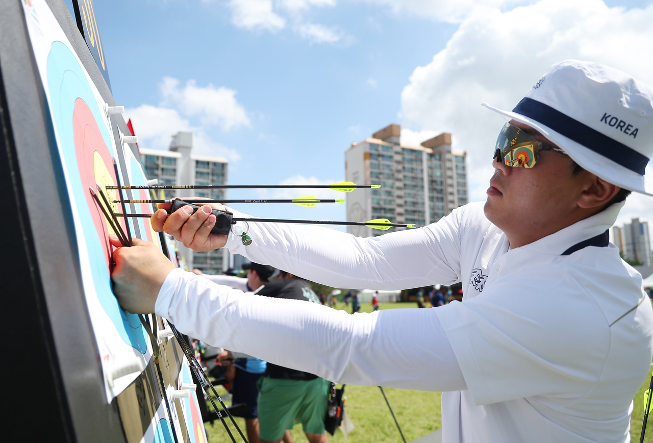 Choi Eun-kyu of South Korea retrieves his arrows after checking the target during the men’s individual compound qualification round at the 2025 World Archery Championships in Gwangju, Saturday. (Yonhap)