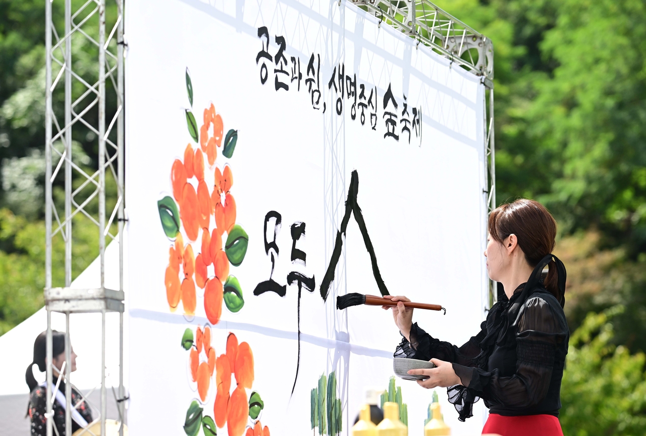 An artist performs live calligraphy during the opening ceremony of Wellness Seoul 2025 on Sunday. (Lee Sang-sub/The Korea Herald)