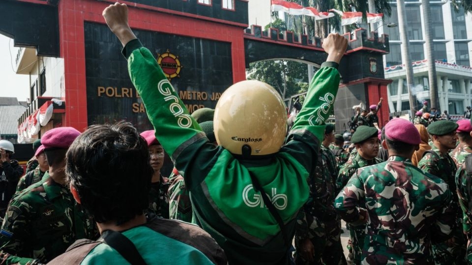 People wearing motorcycle taxi drivers' green jackets take part in a protest in Jakarta, Indonesia.   (Straits Times)