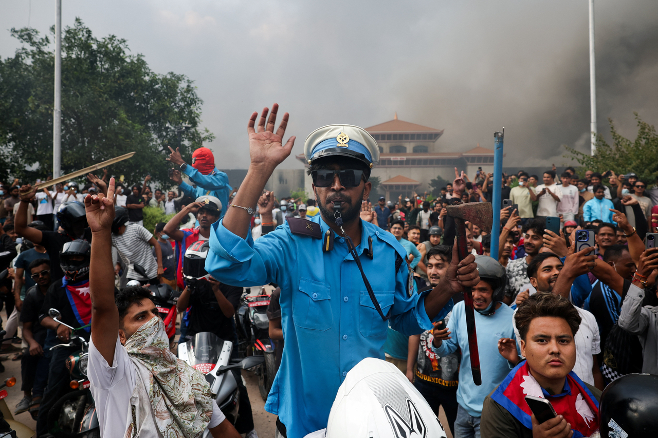 Demonstrators gather near smoke rising from the Parliament complex following fire set during a protest against Monday's killing of 19 people after anti-corruption protests that were triggered by a social media ban, which was later lifted, during a curfew in Kathmandu, Nepal, Sept. 9. (Reuters)