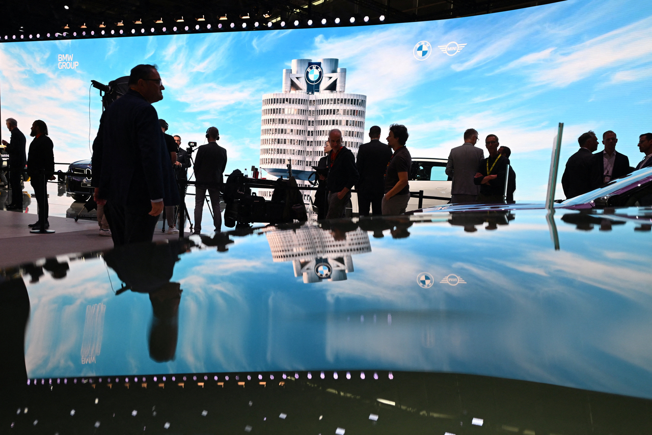 People stand next to BMW vehicles displayed during the press and media day of the IAA auto show in Munich, Germany, Monday.   Reuters-Yonhap