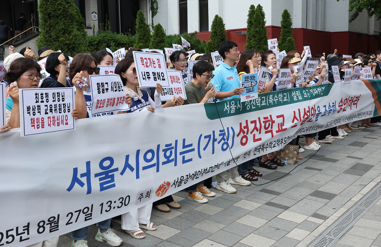 전국장애인부모연대 서울지부 등이 27일 서울 중구 서울시의회 인근에서 연 ‘성진토토사이트추천 설립 촉구’ 기자회견에서 참가자들이 특수토토사이트추천 설립을 촉구하는 손팻말을 들고 있다. [연합]