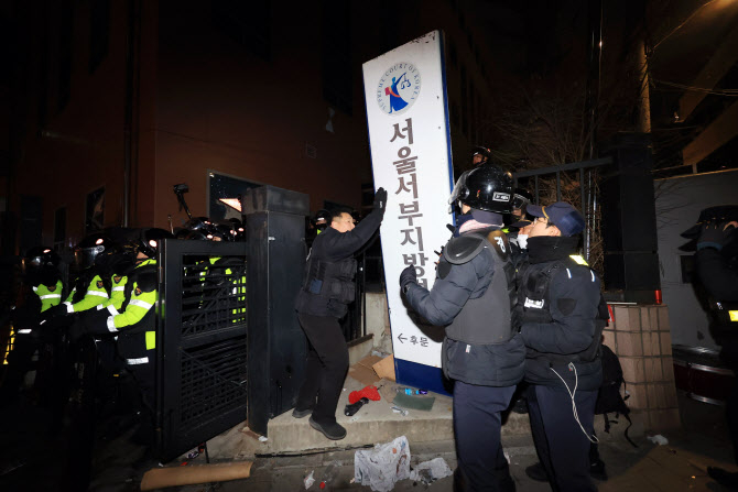 서울 마포구 서울서부지방법원을 습격한 지난 1월 19일 오전 경찰이 해외 토토사이트 운영 후문에서 쓰러진 현판을 세우고 있다. [연합]