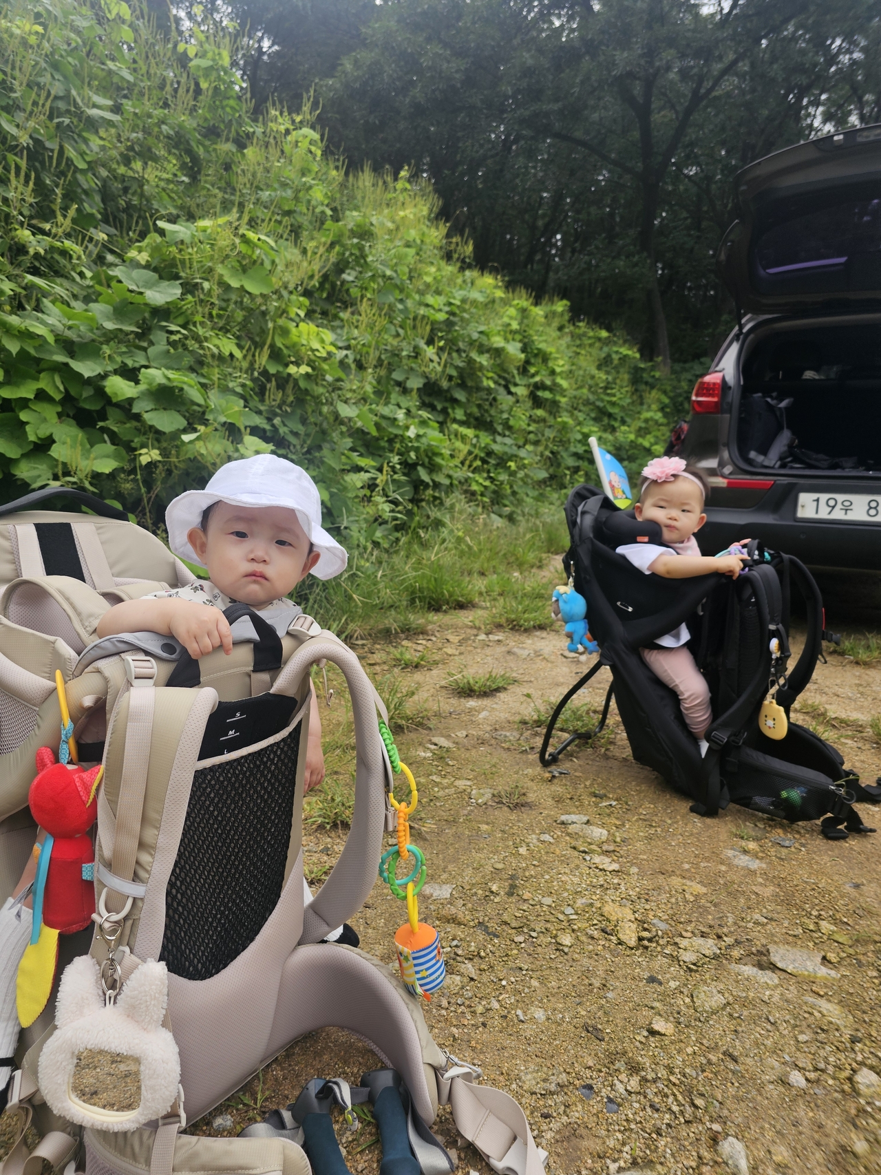 Eager babies wait in their hiking carriers in a parking lot while their parents prepare for the hike. (Choi Jae-hee/The Korea Herald)