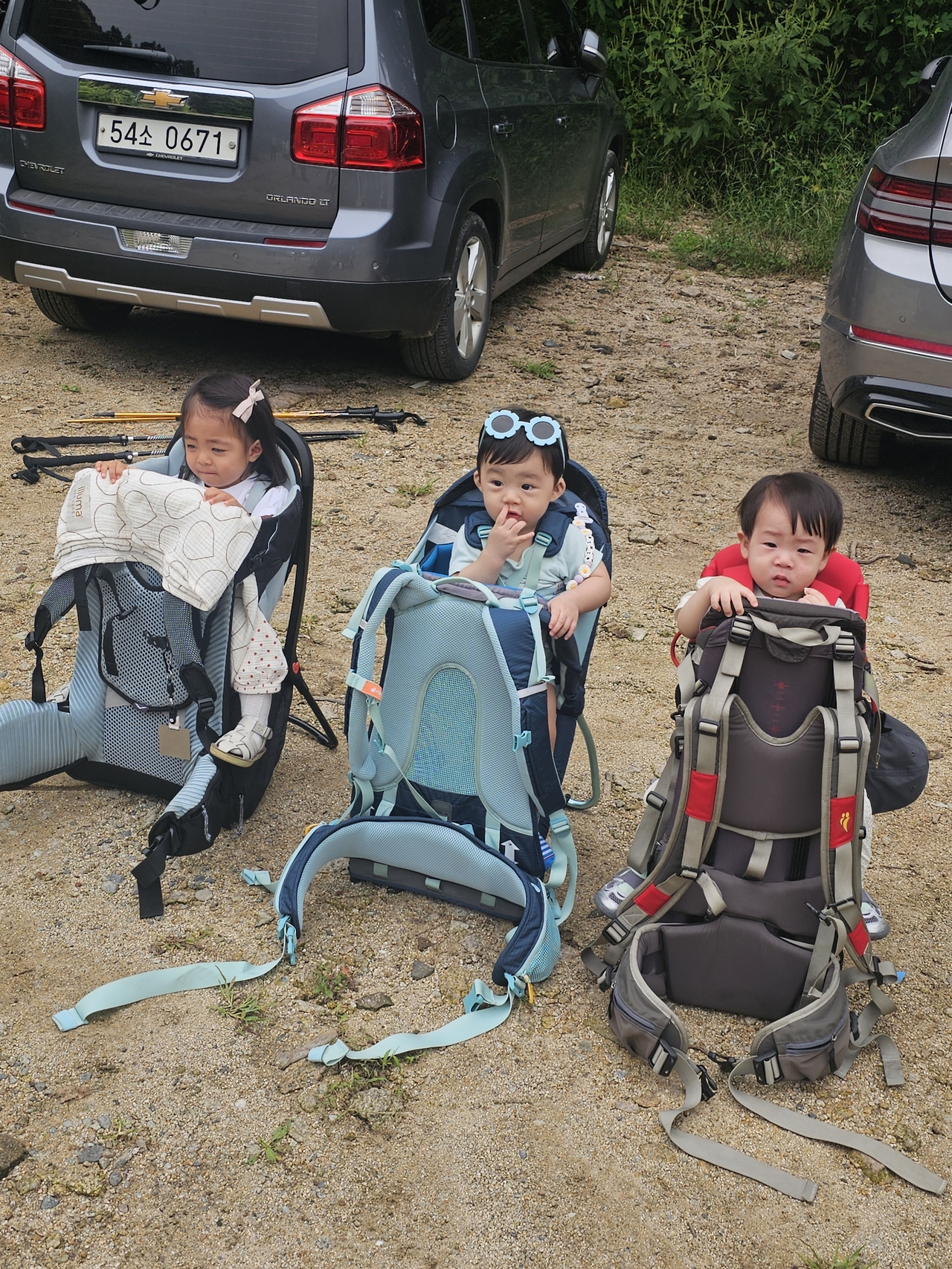 Babies wait in their hiking carriers in a parking lot while their parents prepare for the hike. (Choi Jae-hee/The Korea Herald)