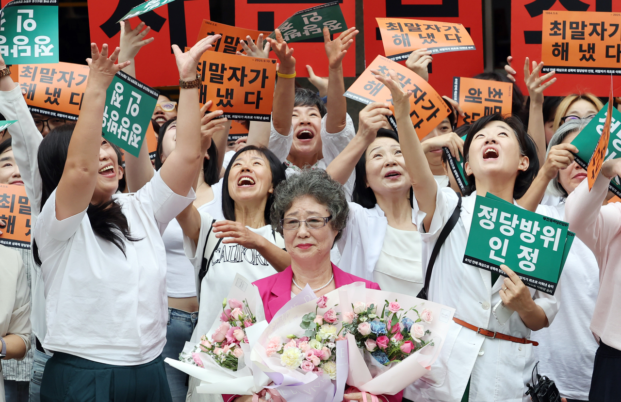 Choi Mal-ja, 79, celebrates with women’s rights activists outside the Busan District Court on Wednesday after being acquitted in a retrial 61 years after she was convicted of injuring her attacker while resisting sexual assault. (Newsis)