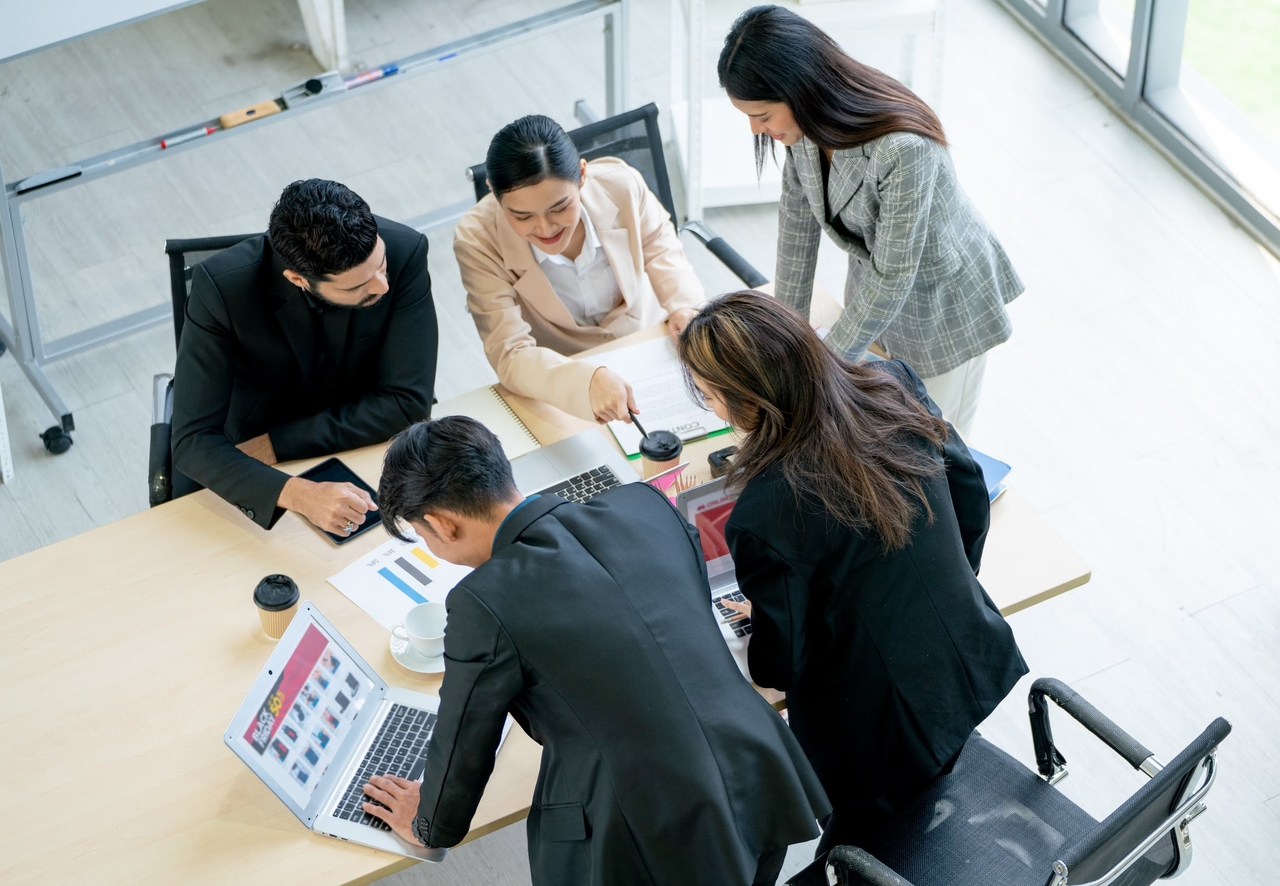 A group of male and female professionals in discussion at the workplace (123rf)
