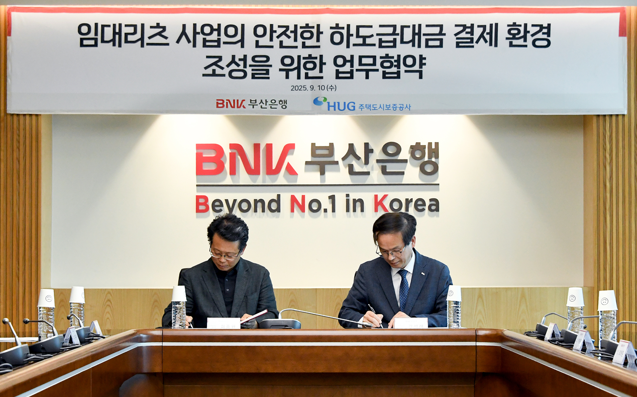 강석래 BNK부산은행 기업고객그룹장(오른쪽)과 최종원 주택도시보증공사 기금사업본부장이 업무협약서에 서명하는 모습. [BNK부산은행 제공]