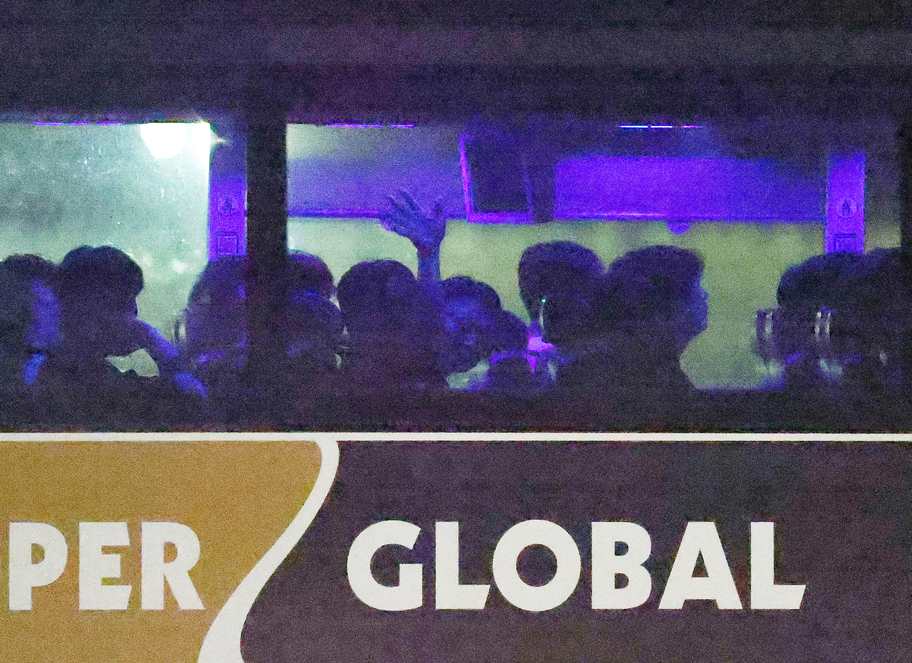 A Korean workers who was detaineed by the US authorities from a large-scale immigration raid at a joint battery plant between Hyundai Motor and LG Energy Solution waves at the press as the detainees were released and got on the bus to head to the Atlanta airport on Thursday. (Yonhap)