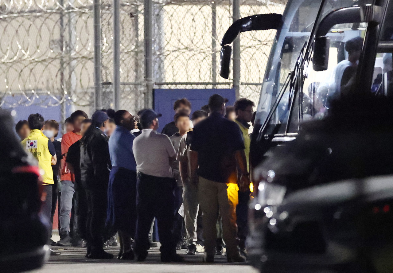 Workers from the Hyundai Motor–LG Energy Solution battery plant construction site, previously detained at an ICE facility in Folkston, Georgia, board a bus to the airport on Thursday. (Yonhap)
