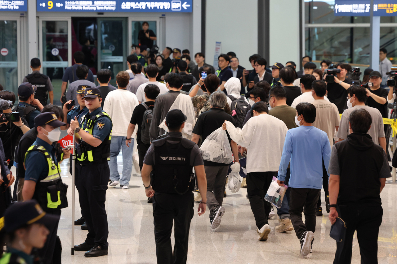South Korean workers who were detained in a Sept. 4 US immigration crackdown leave the arrival hall at Terminal 2 of  Incheon International Airport, Friday. (Yonhap)