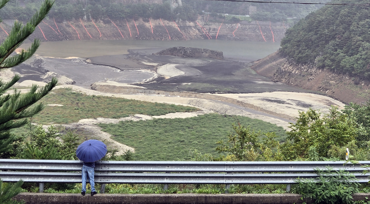 Waters upstream of the Obong Reservoir in Gangneung, Gangwon Province, flow under falling rain on Saturday. (Yonhap)