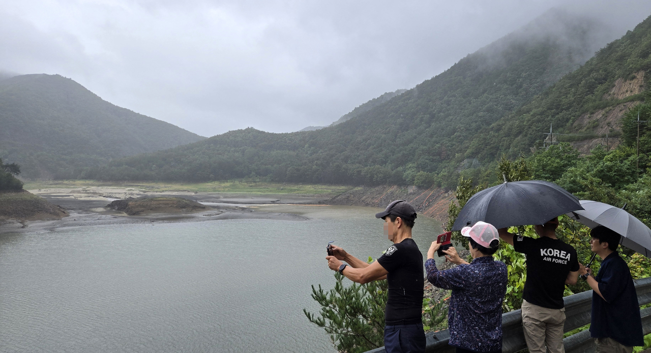 Local residents look out over the Obong Reservoir in Gangneung, Gangwon Province, on Saturday, a vital water source that supplies nearly 87 percent of the city's household water. (Yonhap)
