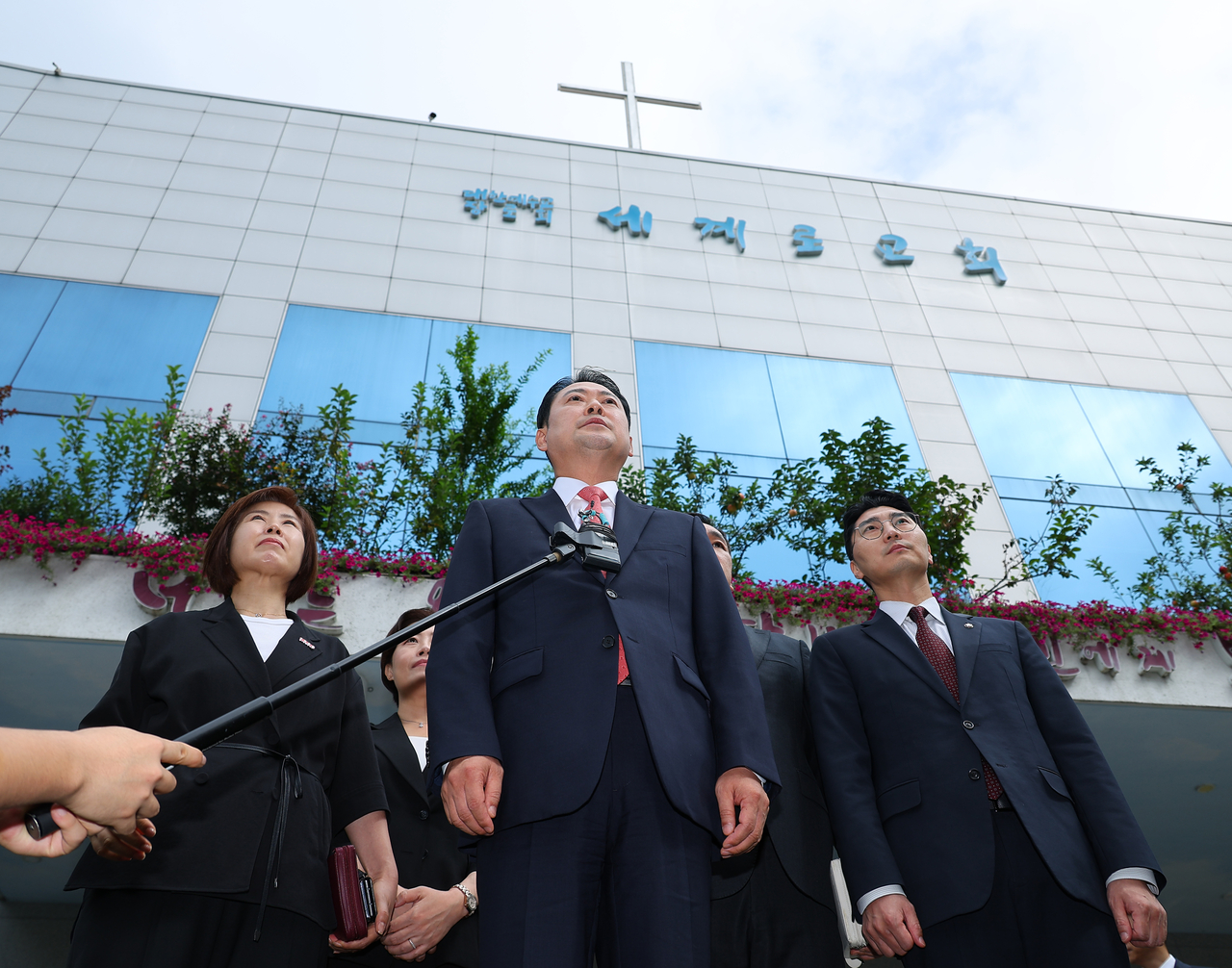 Rep. Jang Dong-hyeok (center), leader of the main opposition People Power Party, speaks to reporters Sunday outside Segero Church in Busan. The party leadership attended a service there in support of head pastor Son Hyun-bo, who was recently arrested for election law violations. Son, leader of the far-right group Save Korea, has organized massive rallies in support of former President Yoon Suk Yeol and publicly backed conservative candidates. (Yonhap)