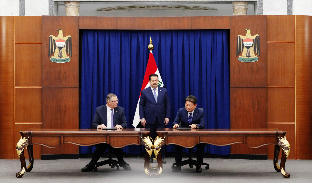 TotalEnergies Chair Patrick Pouyanne (left) and Hyundai E&C plant business division head Ryu Seong-an (right) sign a contract with Iraqi Prime Minister Mohammed Shia' Al-Sudani (center) at his office in Baghdad on Sunday. (Hyundai Engineering & Construction)