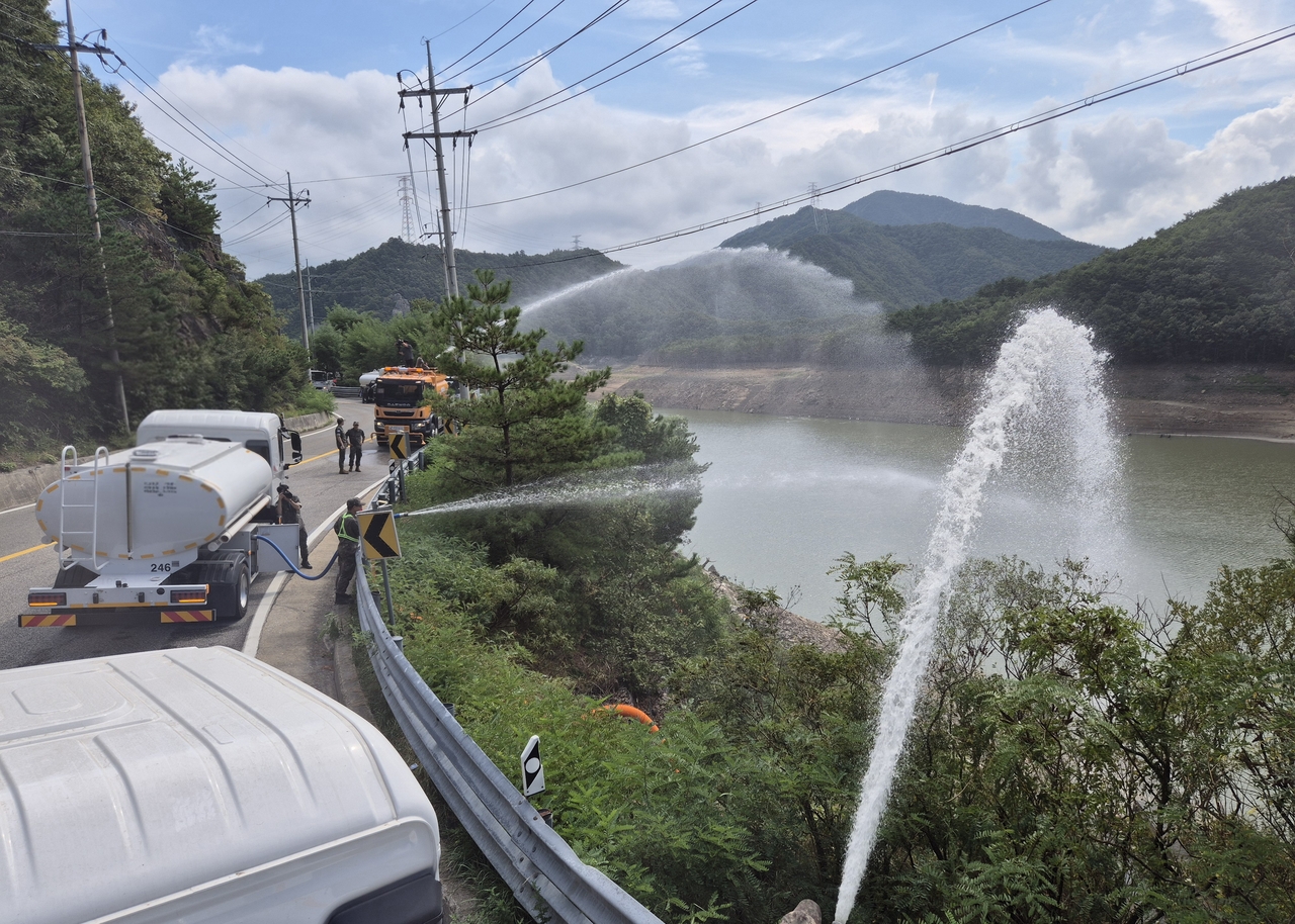 Army water tank trucks pump water into the Obong Reservoir in Gangneung, Gangwon Province, on Sept. 4. (Yonhap)