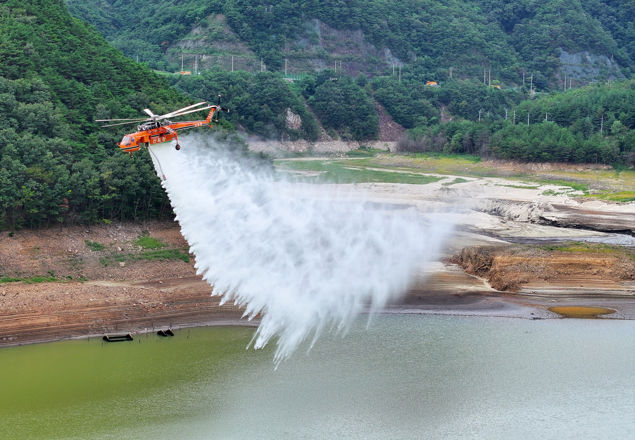 A firefighting helicopter drops water into the Obong Reservoir in Gangneung, Gangwon Province, to help raise water levels, Sept. 5. (Yonhap)