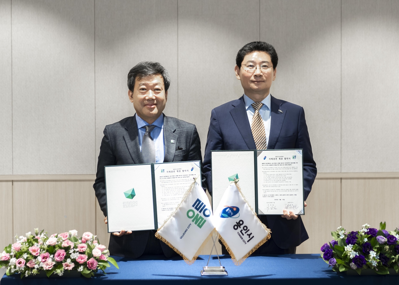 남한권울릉군수(왼쪽)와 이상일 용인특례시장이 자매결연 협약서에 서명한뒤 기념사진을 찍고 있다.[울릉군 제공]