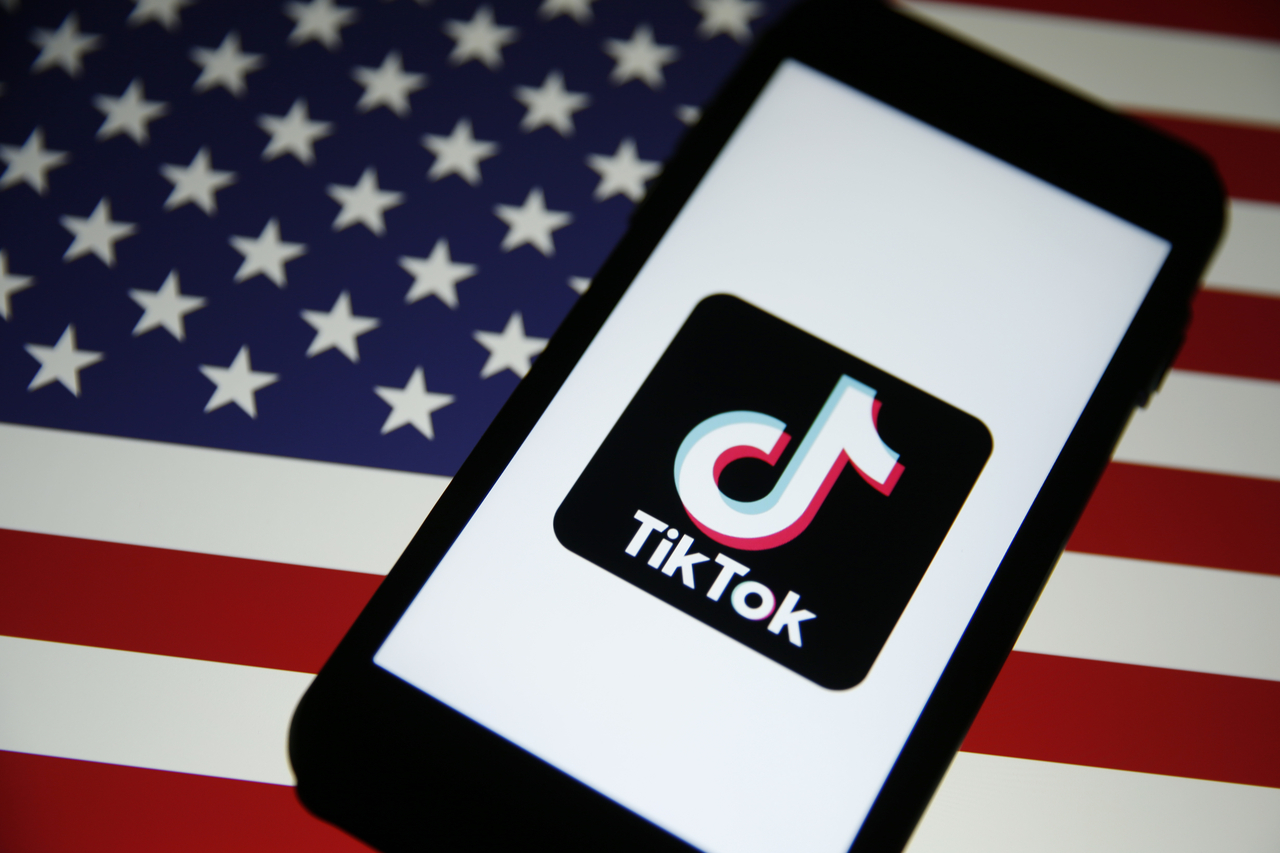 The TikTok logo is displayed in front of an image of the US national flag.   Bloomberg