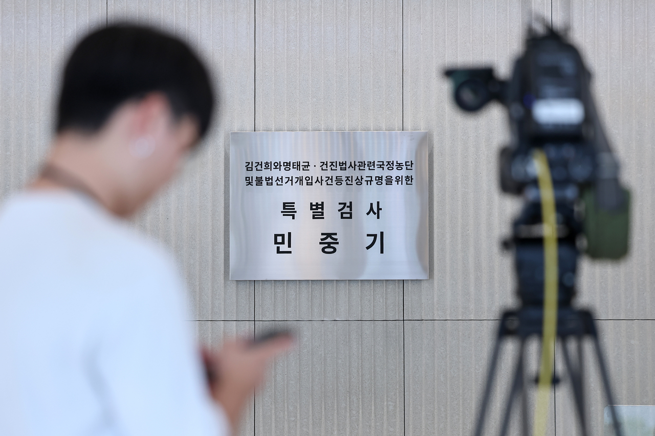 토토사이트 세션 여사와 관련한 각종 의혹 사건을 수사하는 민중기 특별검사 사무실에 걸린 현판 앞에서 취재진이 대기하고 있다. [연합]