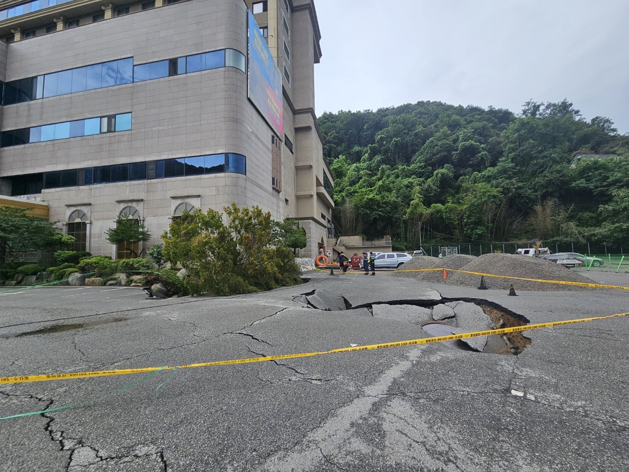 지난 7월 17일 광주 동구 지산동 한 호텔 도로에서 대형 싱크홀이 발생해 통제된 모습.[연합]