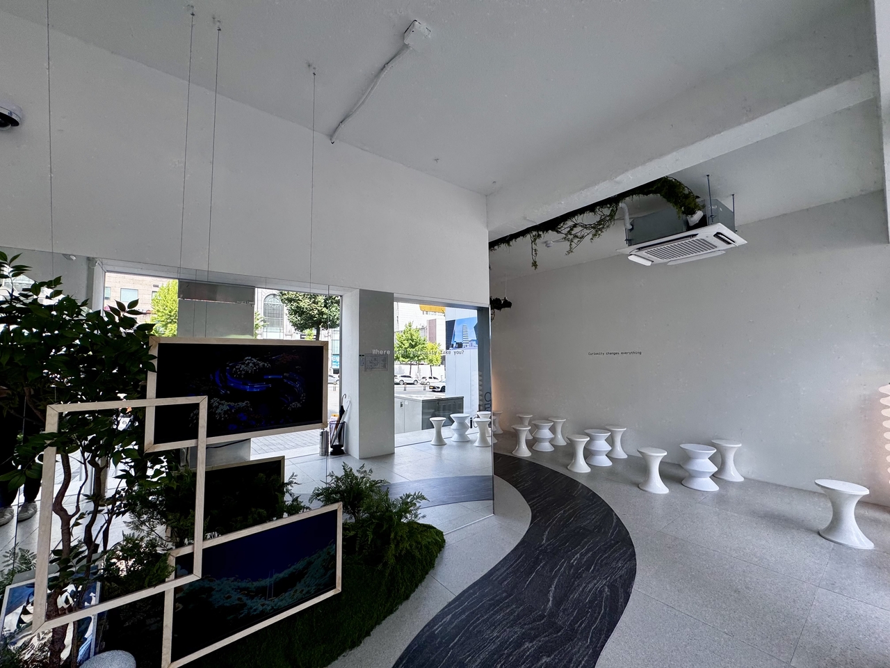Just past the entrance, visitors move through a minimalist transition space filled with soft natural light, abstract stools and phrases like “Curiosity changes everything” printed on the walls and glass. (Moon Joon-hyun/The Korea Herald)