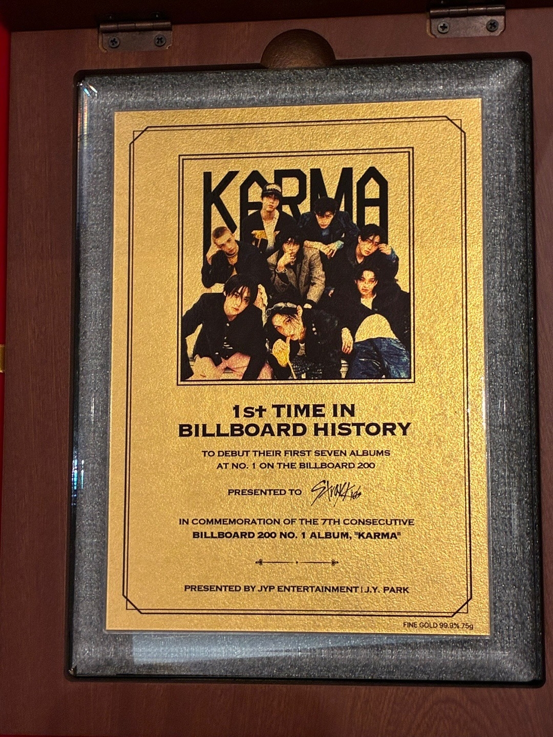 A commemorative gold plaque presented by Park Jin-young honors Stray Kids for becoming the first act in Billboard history to debut their first seven albums at No. 1. (Stray Kids' Instagram)