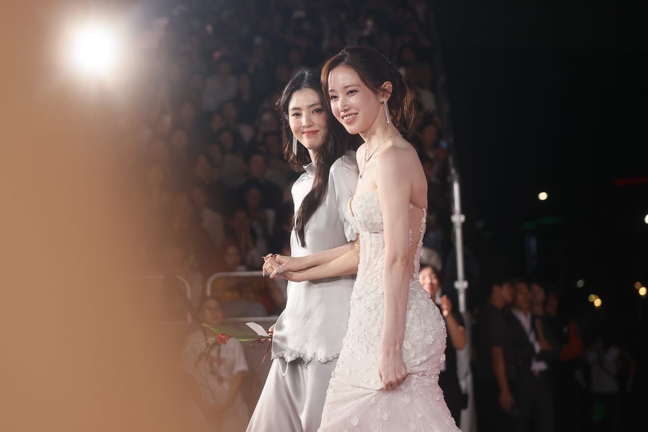 Actors Jun Jong-seo (right) and Han So-hee walk the red carpet at the opening ceremony of the 30th Busan International Film Festival at the Busan Cinema Center in Haeundae-gu, Busan, Wednesday. (Yonhap)
