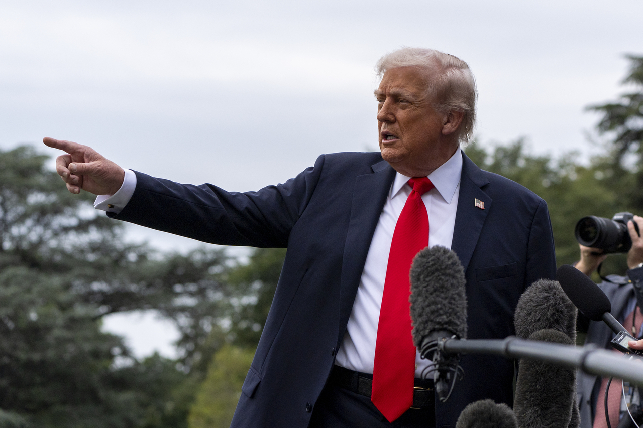 President Donald Trump points to construction as he speaks with reporters before departing on Marine One from the South Lawn of the White House, Tuesday, in Washington. (AP-Yonhap)