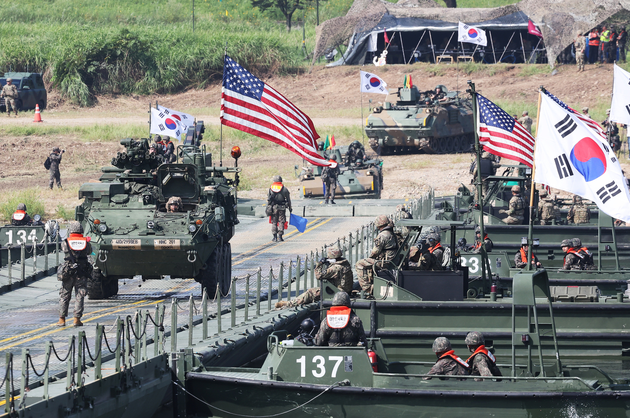 US Stryker armored vehicles and South Korean K200 armored personnel carriers cross a pontoon bridge during a combined river-crossing exercise on the Namhan River in Yeoju, Gyeonggi Province, on Aug. 27. (Yonhap)