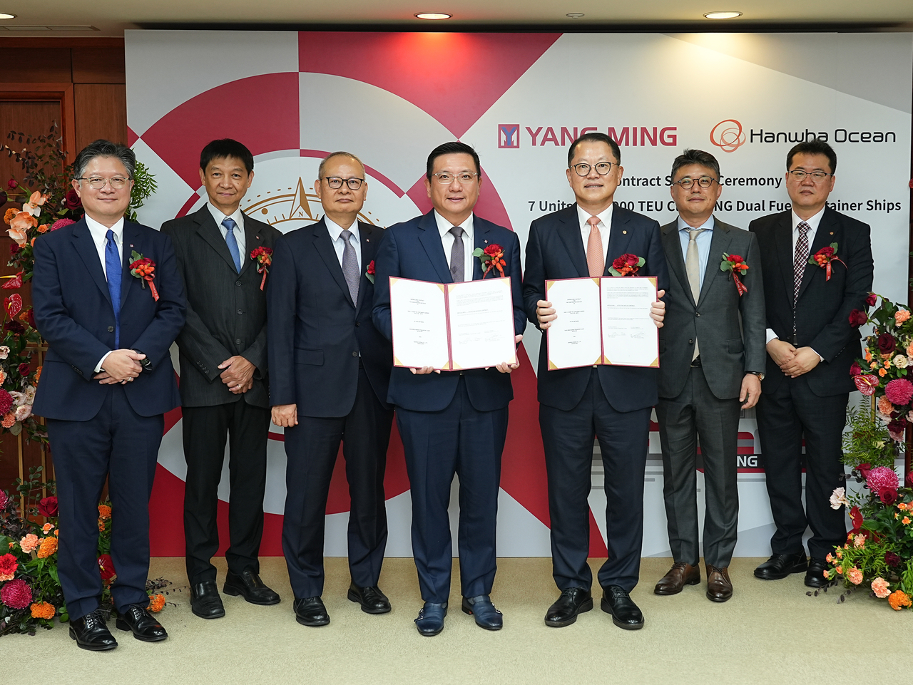 Hanwha Ocean CEO Kim Hee-cheol (third from right) and Yang Ming Chairman Tsai Feng-ming (fourth from right) pose after signing a contract for seven ultralarge container carriers at Yang Ming’s headquarters in Taiwan. (Hanwha Ocean)