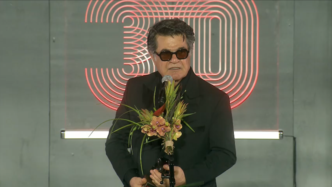 Iranian director Jafar Panahi delivers his acceptance speech after receiving the Asian Filmmaker of the Year award at the opening ceremony of the 30th Busan International Film Festival at the Busan Cinema Center in Haeundae-gu, Busan, Wednesday. (Screen capture from festival's official livestream on CHZZK)