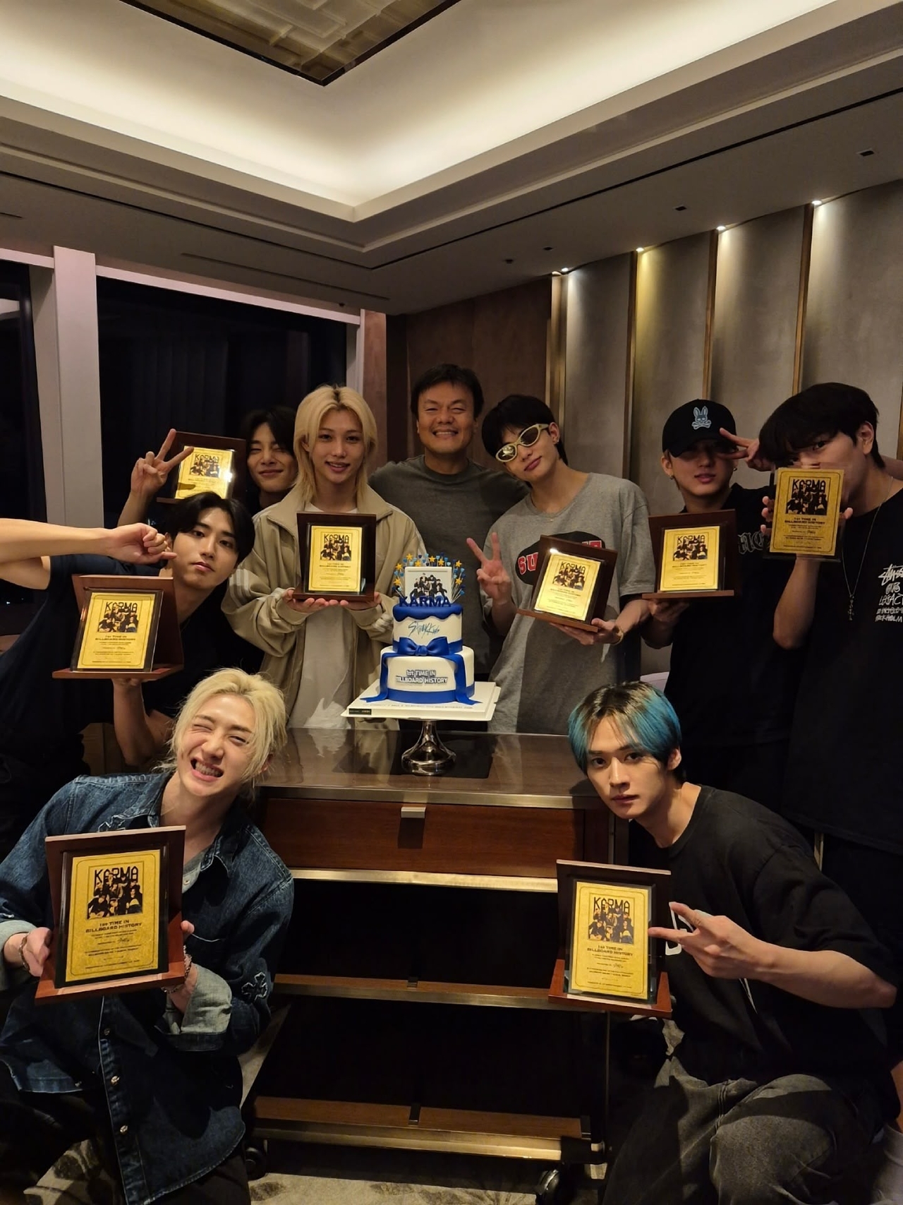 Stray Kids pose with producer Park Jin-young (back center) after receiving commemorative gold plaques marking their Billboard No. 1 album, "Karma." (Stray Kids' Instagram)